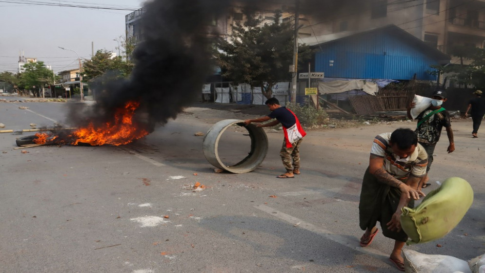 متظاهرين يقيمون حواجز مؤقتة بينما يحترق آخرون الإطارات خلال تظاهرات ضد الانقلاب العسكري في بورما. (أ ف ب)