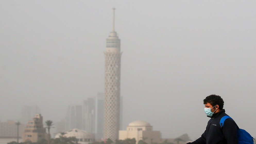 رجل يرتدي كمامة واقية خلال الضباب والطقس البارد وسط جائحة فيروس كورونا (كوفيد -19) في القاهرة، مصر، 16 شباط/ فبراير 2021. (رويترز)