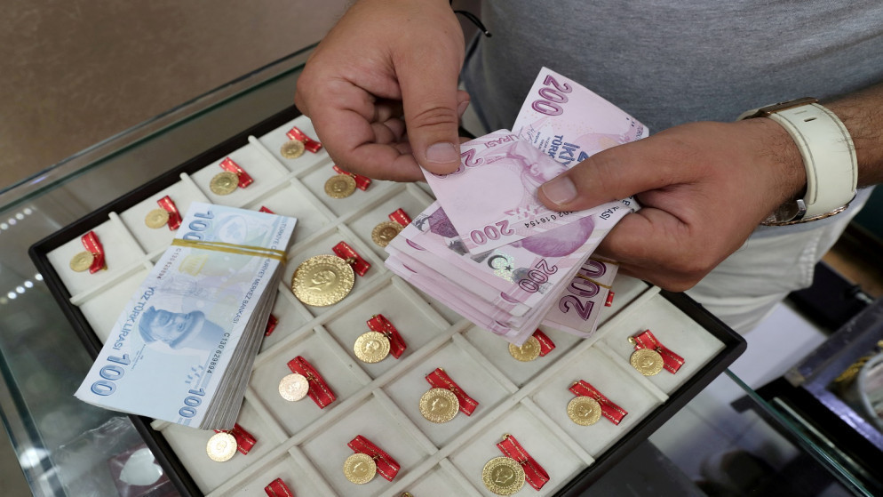 تاجر ذهب يعدّ أوراق النقد بالليرة التركية في متجره في البازار الكبير في إسطنبول، تركيا، 6 آب/ أغسطس 2020. (رويترز)