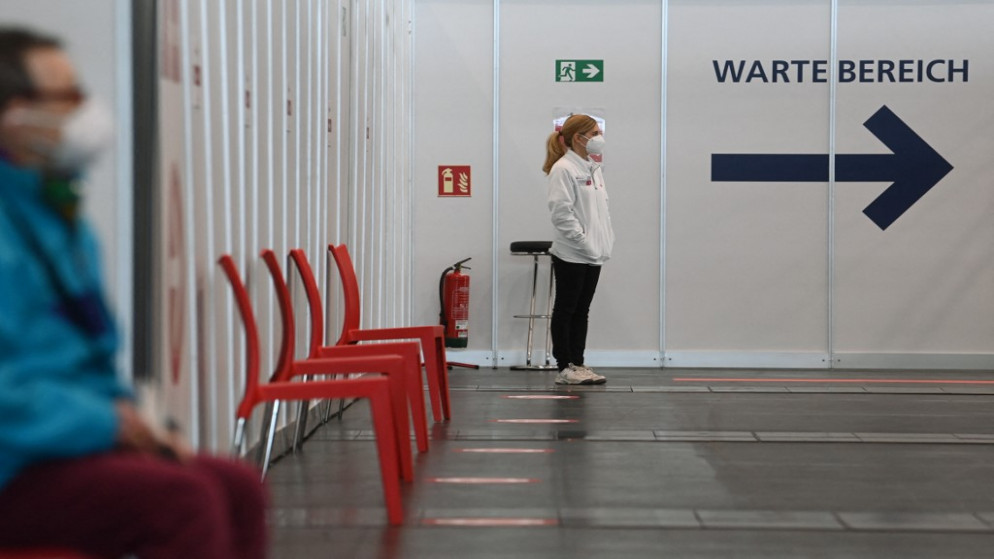 سيدة تقف بانتظار دورها في مركز التطعيم ضد كوفيد-19 في نورمبرج جنوبي ألمانيا. 18/03/2021. (كريستوف ستاتش / أ ف ب)