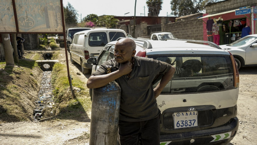 رجل ينتظر إعادة تعبئة أسطوانات الأكسجين لأفراد عائلته المصابين بفيروس كورونا "COVID-19 " في أديس أبابا ، إثيوبيا .19 مارس/آذار 2021.. (أ ف ب)