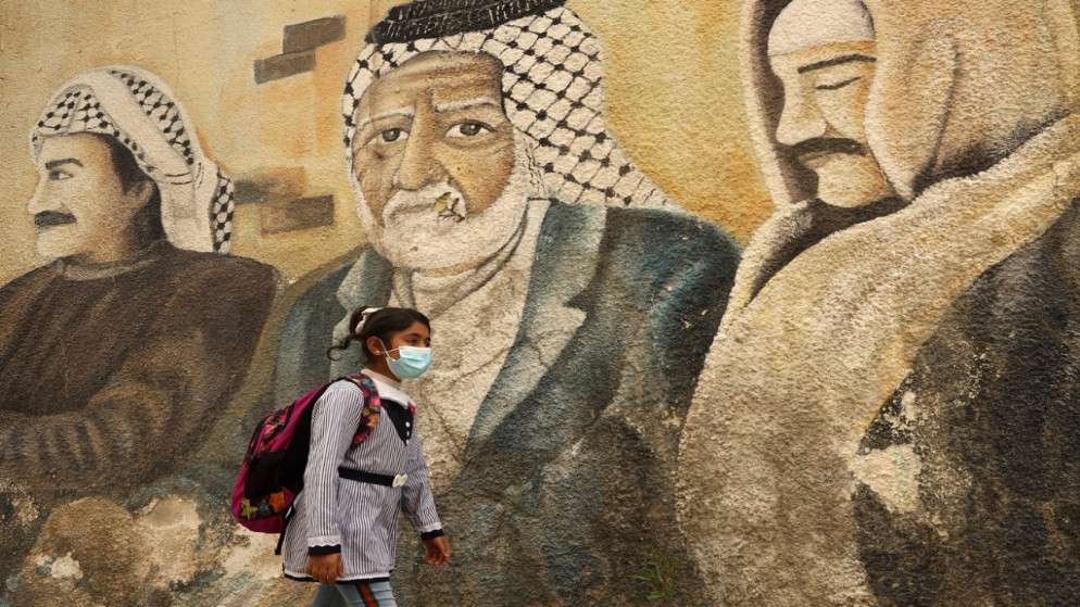 طالبة فلسطينية تمر أمام لوحة جدارية خارج مقر وكالة (أونروا) في مدينة غزة، 18 آذار/مارس 2021. (محمد عابد/ أ ف ب)
