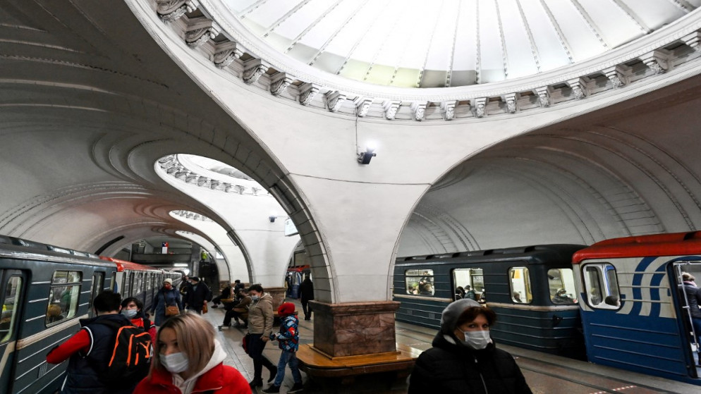 أشخاص يرتدون أقنعة الوجه وكمامات يسيرون في محطة مترو سوكول في موسكو في 25 مارس/آذار 2021. (أ ف ب)