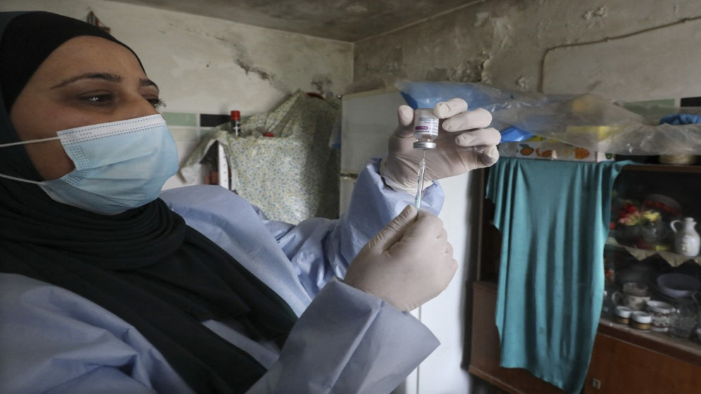 عاملة في القطاع الصحي الفلسطيني تحضر جرعة من لقاح واق من فيروس كورونا. (أ ف ب)