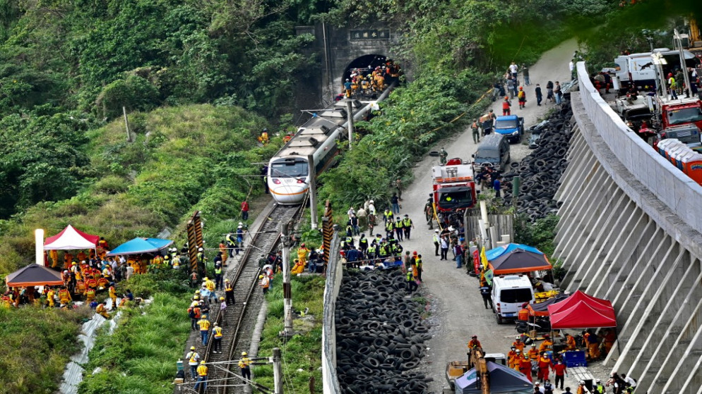 عمال إنقاذ في الموقع الذي خرج فيه قطار عن مساره داخل نفق في جبال هوالين بشرق تايوان في 2 نيسان/ أبريل 2021. (أ ف ب)