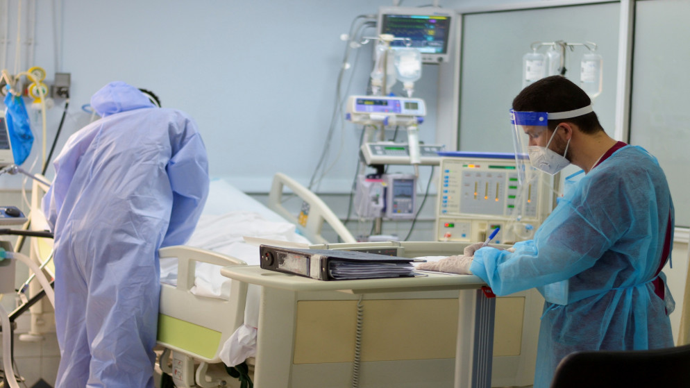 طاقم طبي يرعى مصابا بفيروس كورونا في وحدة العناية الحثيثة في مستشفى في عمان، 23 آذار/مارس 2021. (معاذ فريج /رويترز)