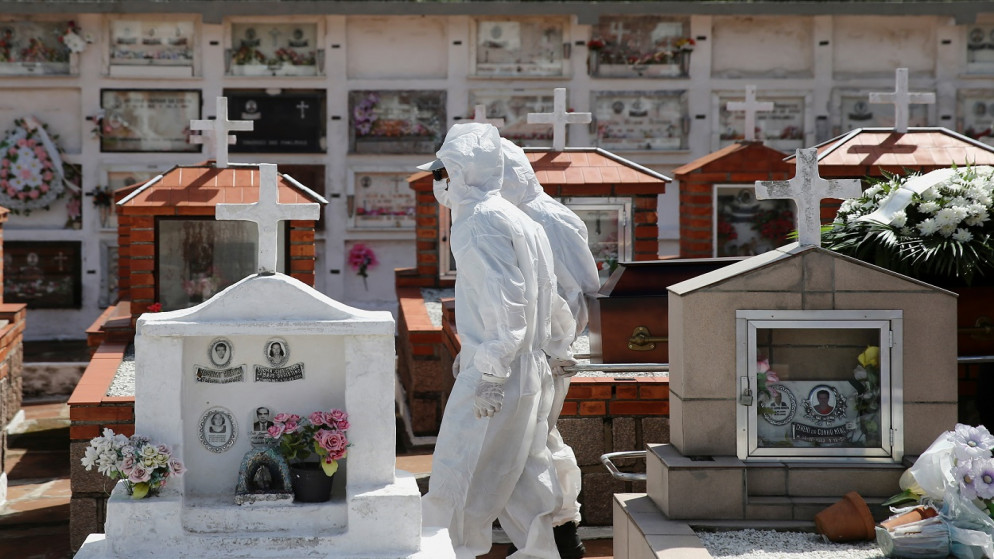 عمال يرتدون ملابس واقية يسحبون تابوت شخص وافته المنية بسبب كورونا، مقبرة بيليم نوفو في بورتو أليغري، البرازيل، 2 نيسان/أبريل 2021. (رويترز)