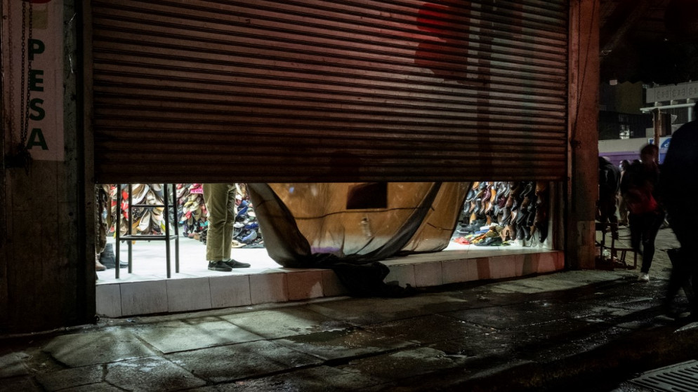صاحب متجر يغلق محله قبل حظر تجول جديد من الساعة 8 مساءً حتى 4 صباحًا في وسط مدينة نيروبي ، كينيا ، في 27 آذار /مارس 2021. (أ ف ب)