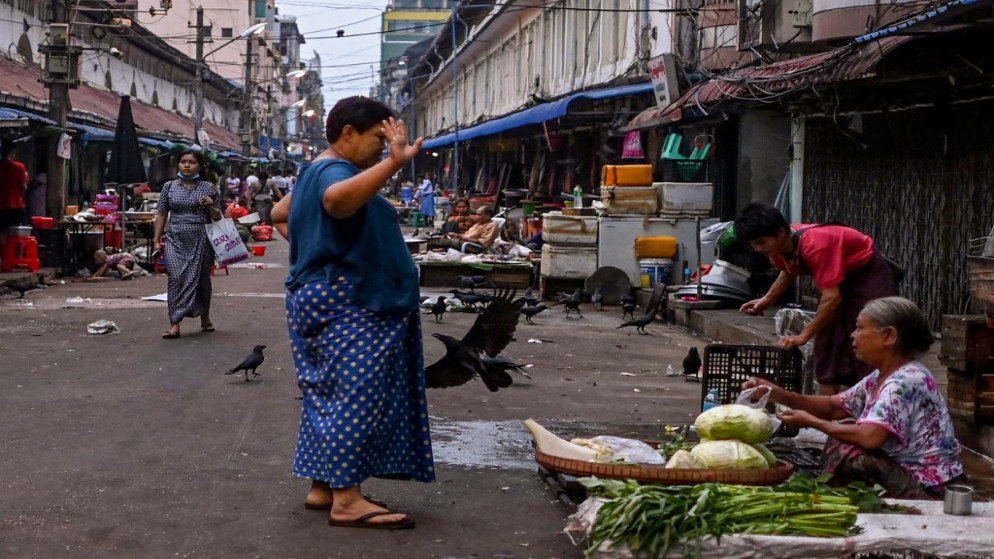امرأة تشتري من بائعة خضراوات في الشارع .يانغون. 2 نيسان /أبريل 2021. (أ ف ب)