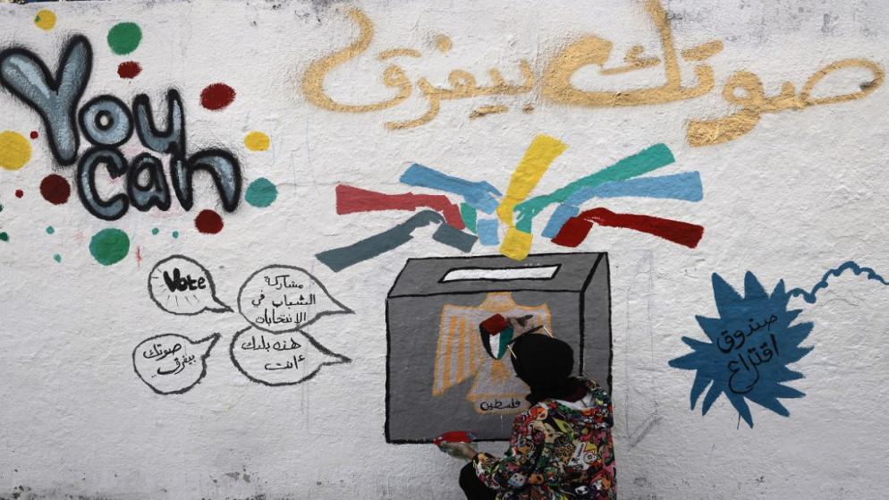 فنان فلسطيني يضيف اللمسات الأخيرة على لوحة جدارية تدعو الناس إلى التصويت خلال الانتخابات المقبلة (التشريعية في مايو والرئاسية في يوليو) في أحد شوارع مدينة غزة .24 آذار/مارس 2021..(أ ف ب)