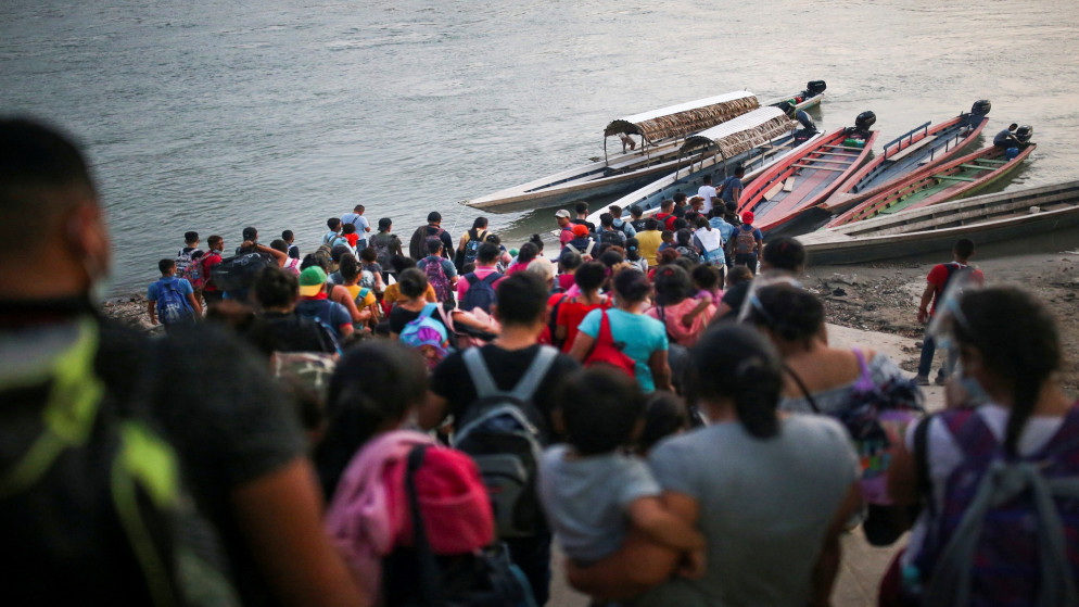صورة لمهاجرين يريدون صعوب مراكب لعبور نهر. (رويترز)