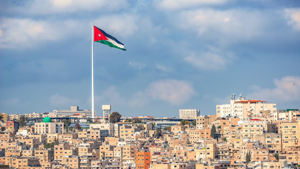 منظر عام لمدينة عمّان ويتوسطها علم الأردن. (shutterstock)