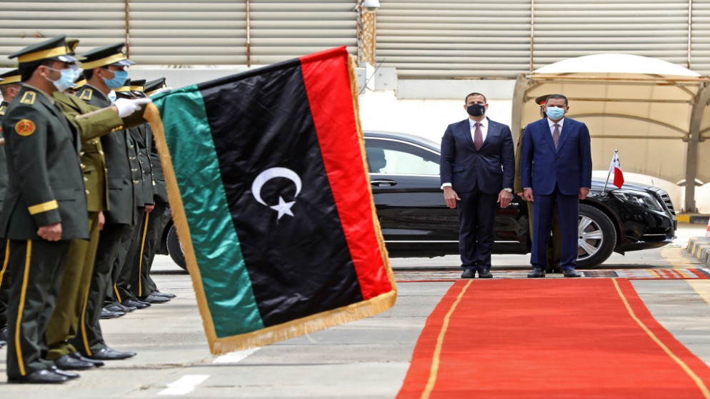 رئيس الوزراء الليبي المؤقت عبد الحميد دبيبة (إلى اليمين) ورئيس الوزراء المالطي روبرت أبيلا (الثاني إلى اليمين) يستعرضان حرس الشرف في العاصمة طرابلس في 5 مارس/آذار 2021 ، خلال زيارة رئيس وزراء مالطا إلى ليبيا.(أ ف ب)