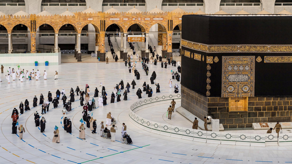 حجاج يرتدون الكمامة ويحافظون على مسافة التباعد الاجتماعي خلال الطواف حول الكعبة. (رويترز)
