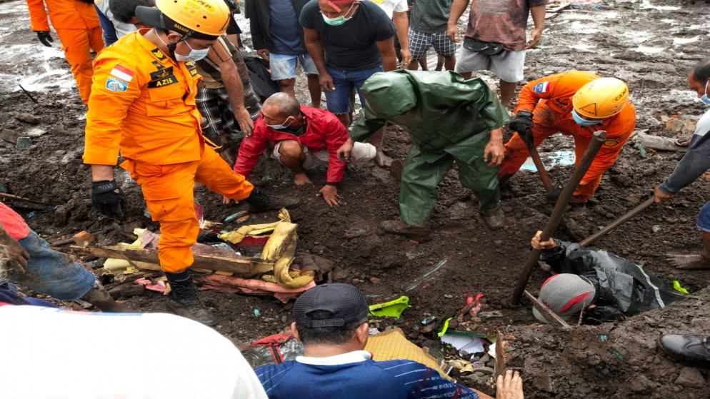 عاملو إنقاذ إندونيسيون يبحثون عن جثة في منطقة تأثرت بالفيضانات المفاجئة بعد هطول أمطار غزيرة في إيست فلوريس في مقاطعة نوسا تينجارا الشرقية في إندونيسيا، 5 نيسان/أبريل 2021. (رويترز)
