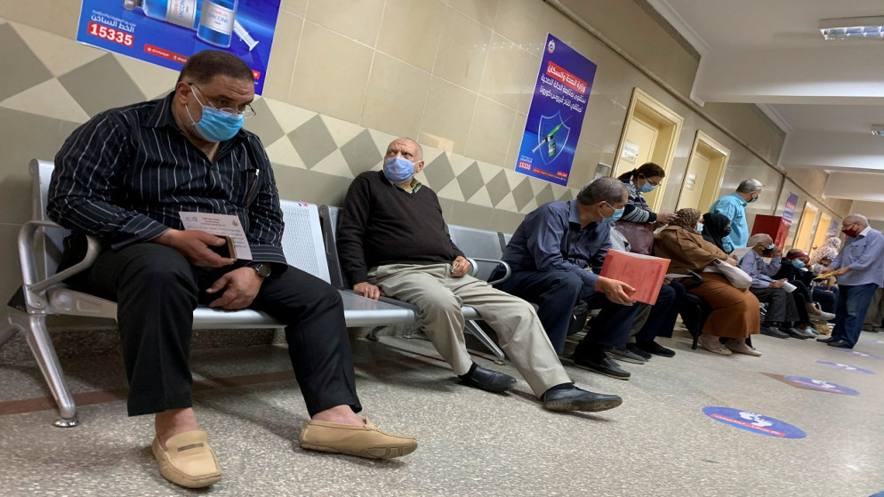 أشخاص يرتدون كمامات واقية للوجه وسط تفشي كورونا، ينتظرون تلقي جرعة من لقاح COVID-19 في مركز صحي، في القطامية، القاهرة، مصر، 22 آذار/ مارس 2021. (رويترز)