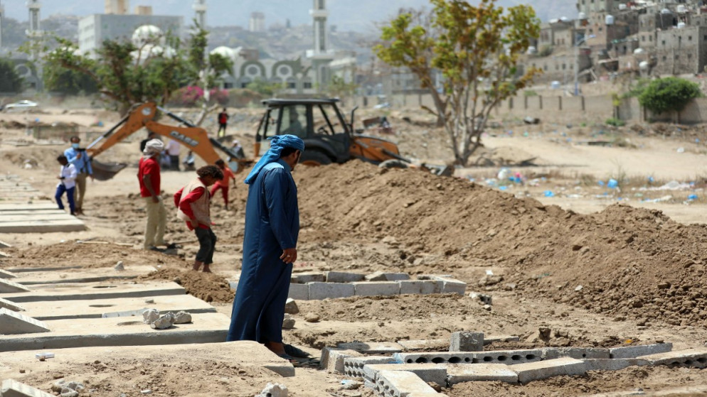 يمنيون يستخدمون حفارة لحفر قبور لضحايا كوفيد -19 في مقبرة بمدينة تعز في اليمن . 3 أبريل / نيسان 2021 .(أ ف ب)