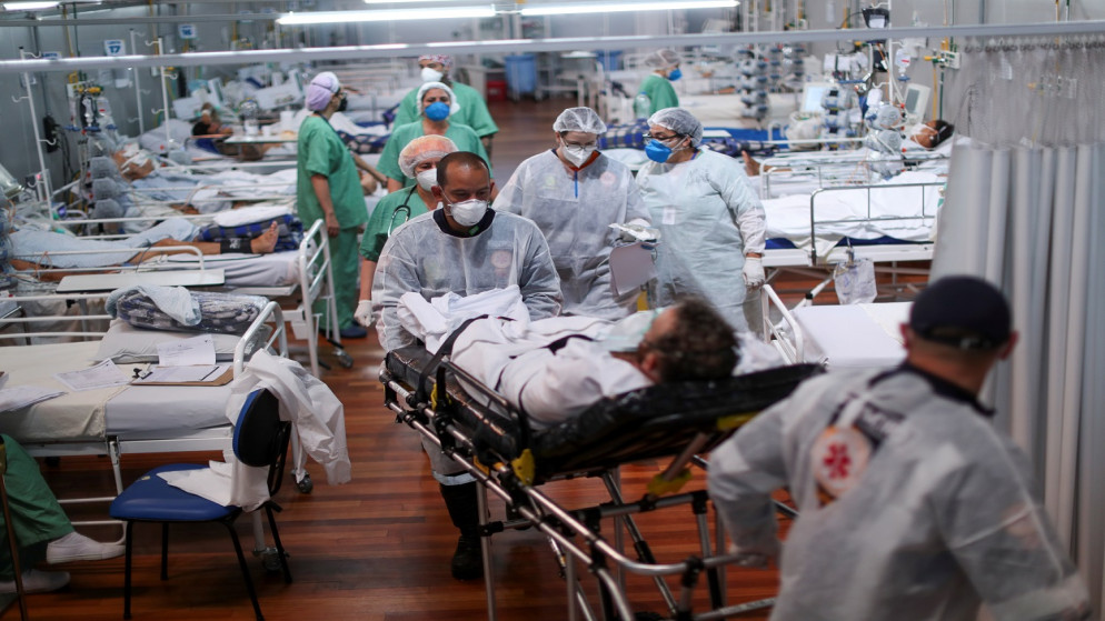 نقل مريض يعاني من الفيروس، في مستشفى ميداني أقيم في صالة الألعاب الرياضية في سانتو أندريه، في ضواحي ساو باولو، البرازيل، 7 نيسان/ أبريل 2021. (رويترز)