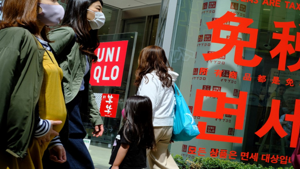 يابانيون أمام متجر ملابس Uniqlo تديره شركة Fast Retailing اليابانية في طوكيو .8 نيسان/أبريل 2021.(أ  ف ب)