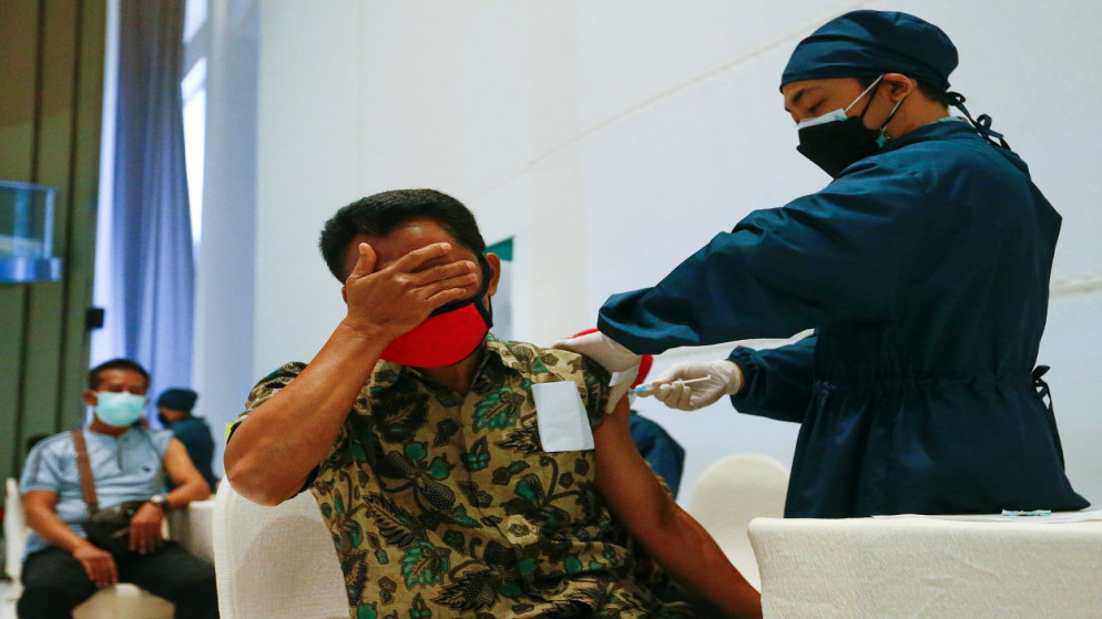 رجل يتفاعل عندما يتلقى جرعة من لقاح Sinovac Biotech الصيني لمرض فيروس كورونا (COVID-19) خلال برنامج التطعيم الشامل في مركز تسوق في جاكرتا، إندونيسيا، 1 أبريل 2021.