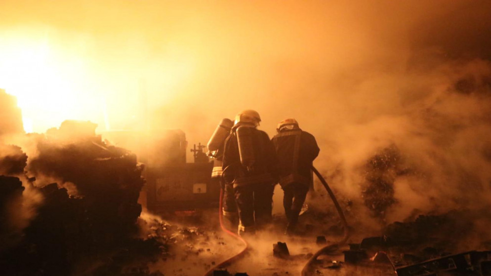كوادر الإطفاء في مديرية دفاع مدني شرق عمّان تقوم بإخماد حريق شب داخل منجرة ومستودع فحم شواء بمنطقة سحاب. (مديرية الأمن العام)