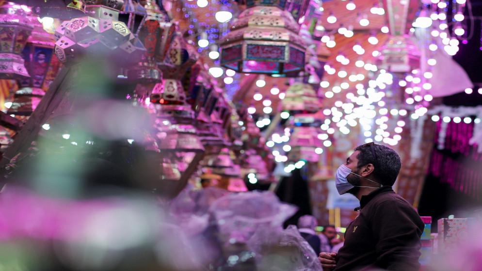 رجل يتفقد فانوس رمضان التقليدي، في كشك تجاري قبل حلول شهر رمضان المبارك، وسط جائحة كورونا، القاهرة، مصر، 8 أبريل 2021. (رويترز)