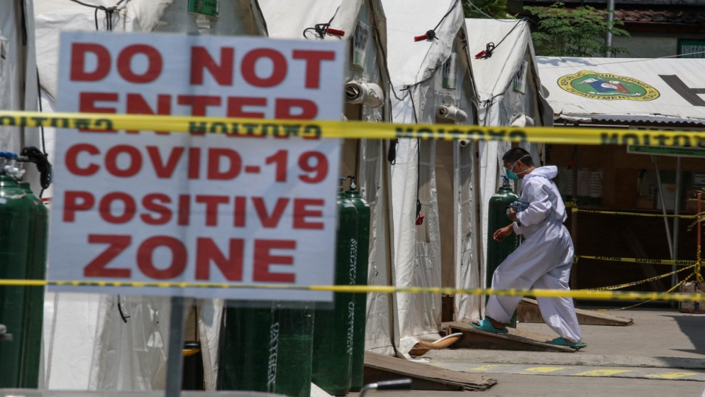 رجل يرتدي معدات الحماية الشخصية وهو يسير في جناح مؤقت تم بناؤه لمرضى كوفيد-19 في مستشفى في مانيلا بالفلبين. 06/04/2021. (جام ستا روزا / أ ف ب)