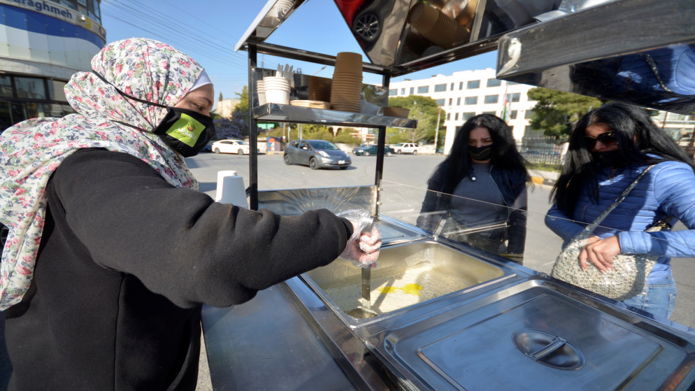 ساجدة أسعد، أم تبلغ من العمر 31 عاما، تبيع وجبة الرشوف في عربتها في عمّان وسط قيود أزمة فيروس كورونا. 31/03/2021.(معاذ فريج/ رويترز)