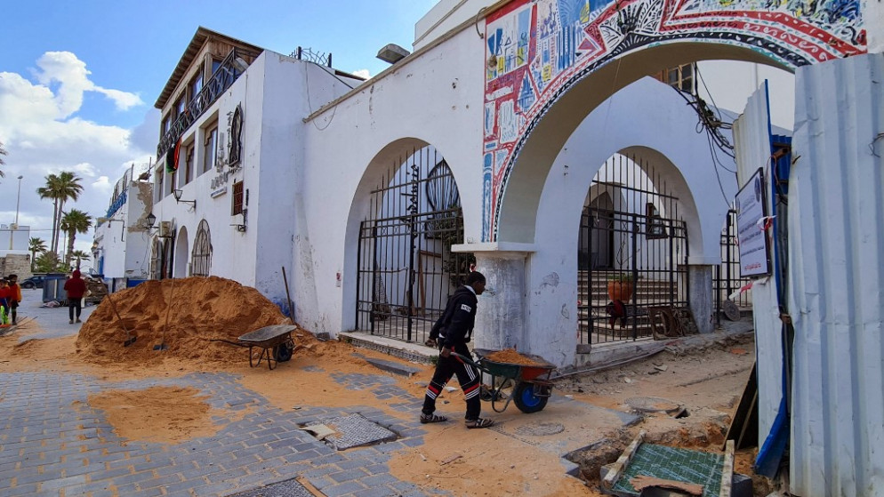 عمال يعملون في مشروع إعادة تأهيل البنية التحتية في زقاق بالعاصمة الليبية طرابلس القديمة . 23 مارس/آذار 2021. (محمود تركيا / أ ف ب)