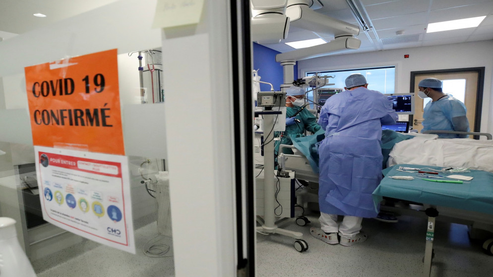عاملون في القطاع الصحي يعتنون بمريض يعاني من مرض كوفيد-19 في وحدة العناية المركزة في مستشفى ببلجيكا. 06/04/2021. (إيف هيرمان/ أ ف ب)