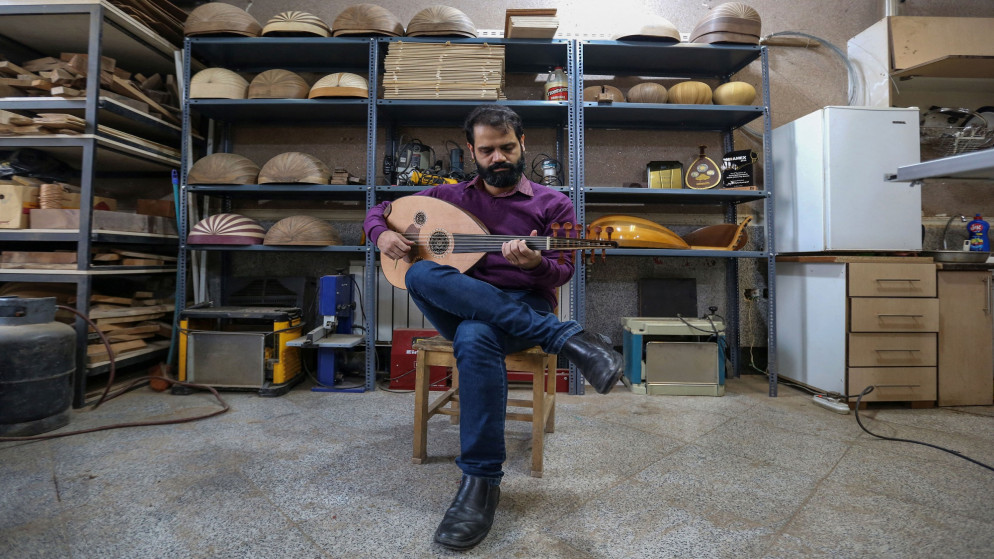 حميد خنساري، عازف ومدرب إيراني يختبر آلة جديدة في ورشة لوثير فاطمة موسوي لصنع العود في العاصمة طهران. 14/12/2021. (أتا كيناري /أ ف ب)