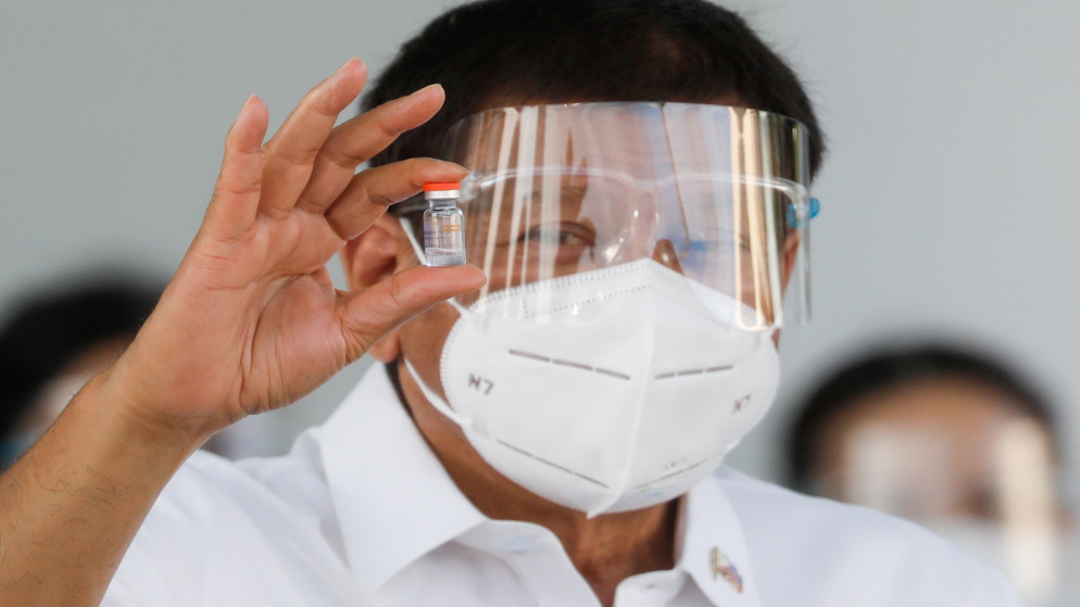 رئيس الفلبين رودريجو دوتيرتي يحمل عبوة لقاح سينوفاك مضاد لفيروس كورونا في مدينة باساي بالفلبين. 28/02/2021. (إلويزا لوبيز/ رويترز)