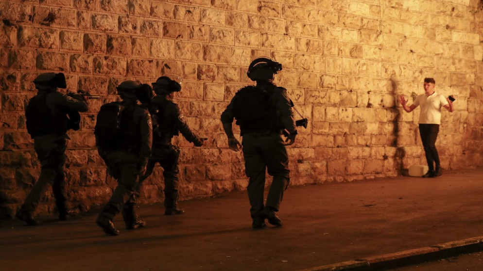 جنود الاحتلال الإسرائيلي يرفعون بنادقهم بوجه فلسطيني في البلدة القديمة في القدس .23 أبريل / نيسان 2021.(أ ف ب)