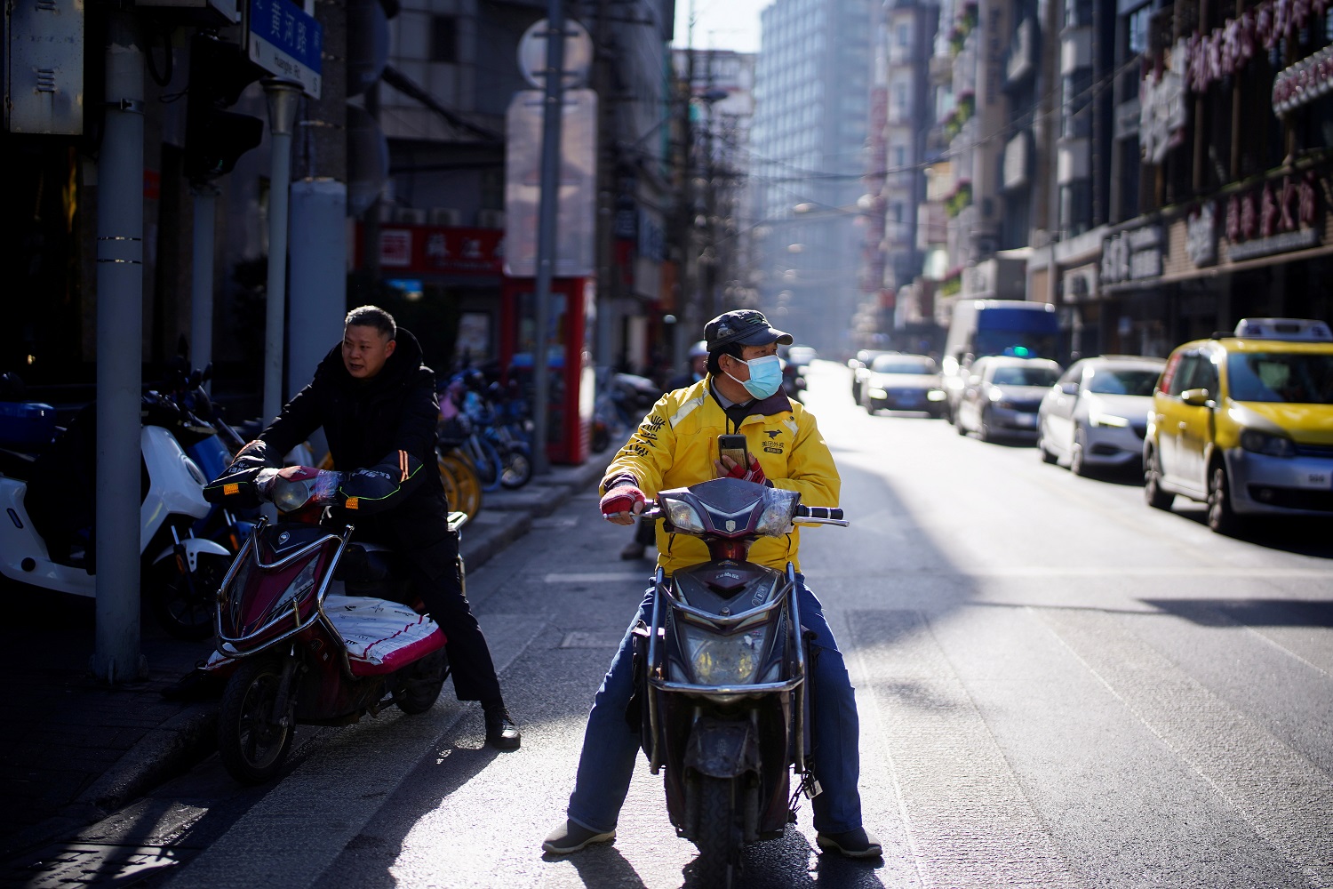 عامل توصيل في ميتوان يرتدي قناع وجه في أحد الشوارع بعد تفشي مرض فيروس كورونا (كوفيد -19) في شنغهاي ، الصين ، في 13 يناير / كانون الثاني 2021. (أ ف ب)