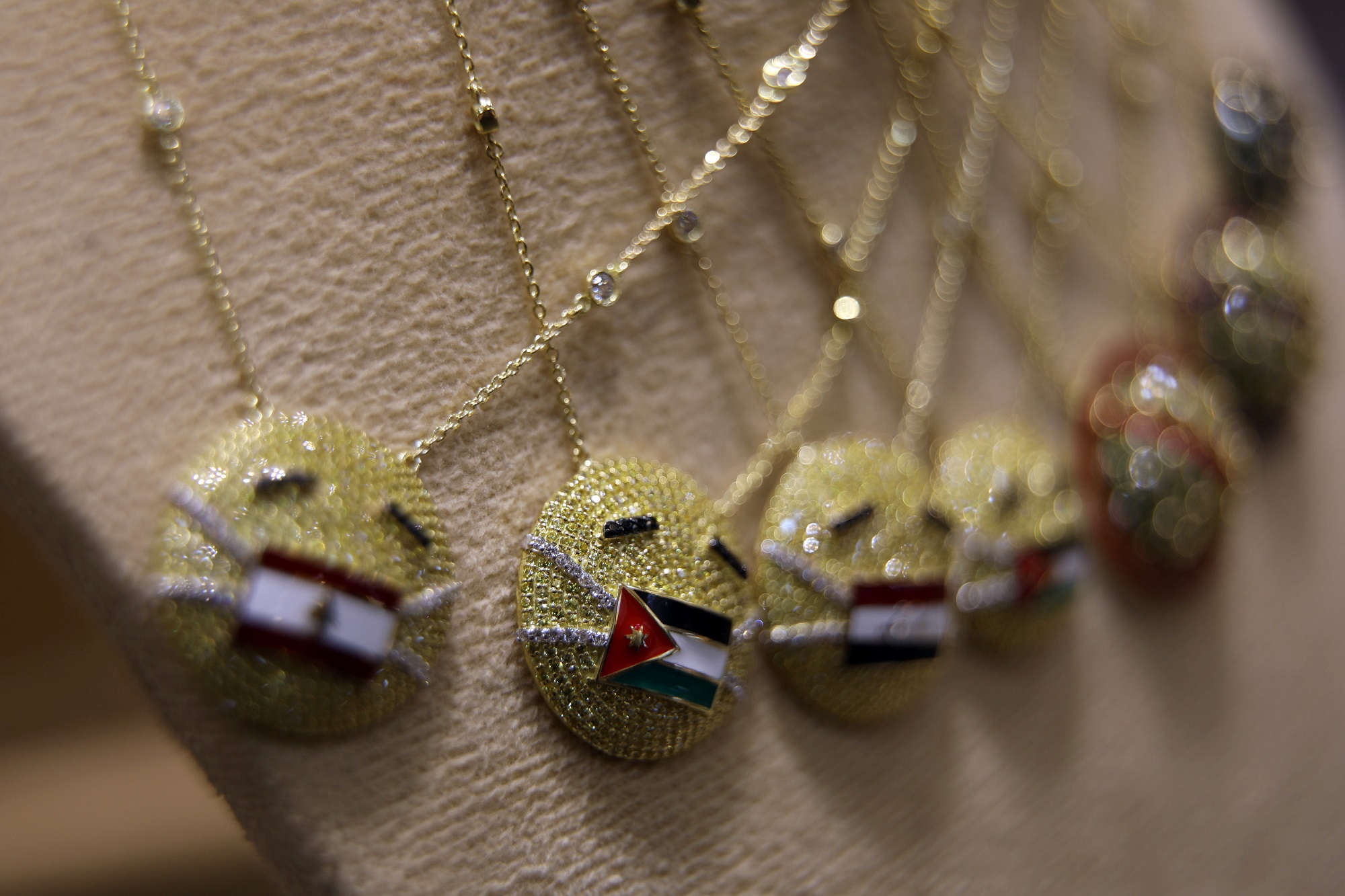 قلادة ذهبية تحمل أعلام دول عربية بينها الأردن في محل مجوهرات بعمّان. (رويترز)