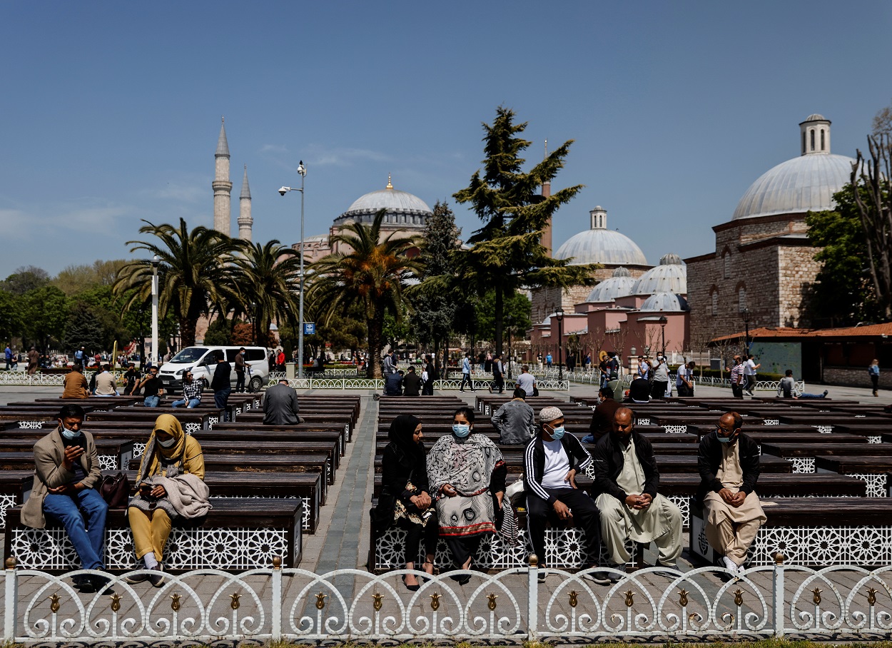 يستمتع السياح بيوم مشمس خارج مسجد آيا صوفيا الكبير، وسط انتشار فيروس كورونا، اسطنبول ، تركيا، 30 أبريل/ 2021. (رويترز)