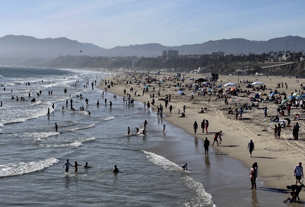 يستمتع الناس بالطقس الدافئ على شاطئ سانتا مونيكا، كاليفورنيا، 30 أبريل/نيسان 2021. (أ ف ب)