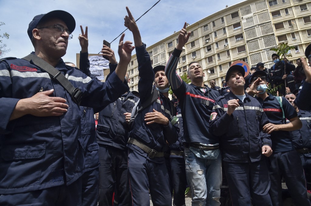 عناصر من الحماية المدنية الجزائرية، يوجهون مسيرة نحو مقر الجهاز بالعاصمة الجزائر، 2 أيار/مايو 2021. (أ ف ب)