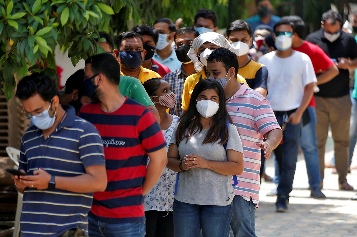 أشخاص ينتظرون لتلقي جرعة من القاح المضاد للفيروس، وهو لقاح لمرضى كورونا، تم تصنيعه بواسطة معهد سيروم في الهند، خارج مركز تطعيم في أحمد آباد ، الهند، 1 مايو 2021. (رويترز)