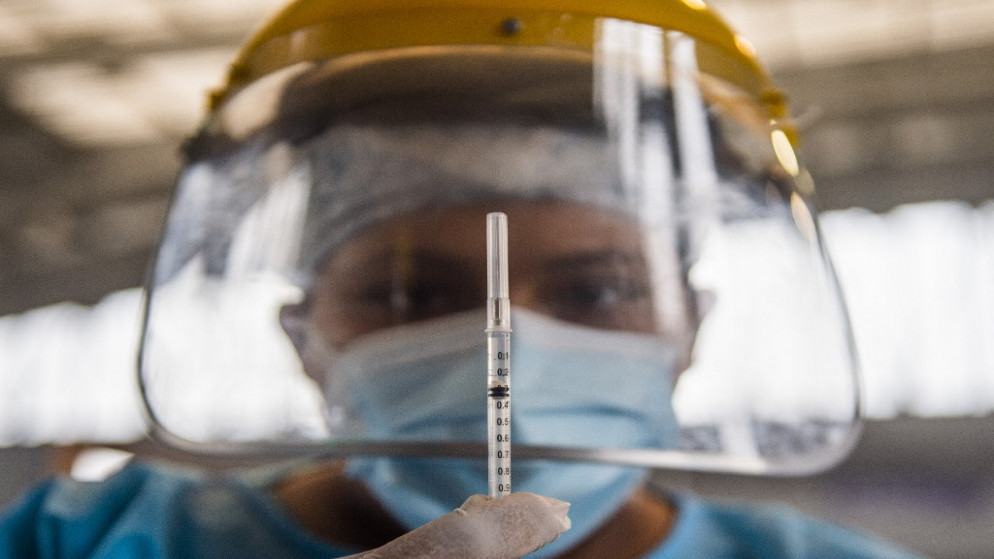 صورة توضيحية لعامل في القطاع الصحي يستعد لإعطاء جرعة من اللقاح المضاد لفيروس كورونا. (أ ف ب)
