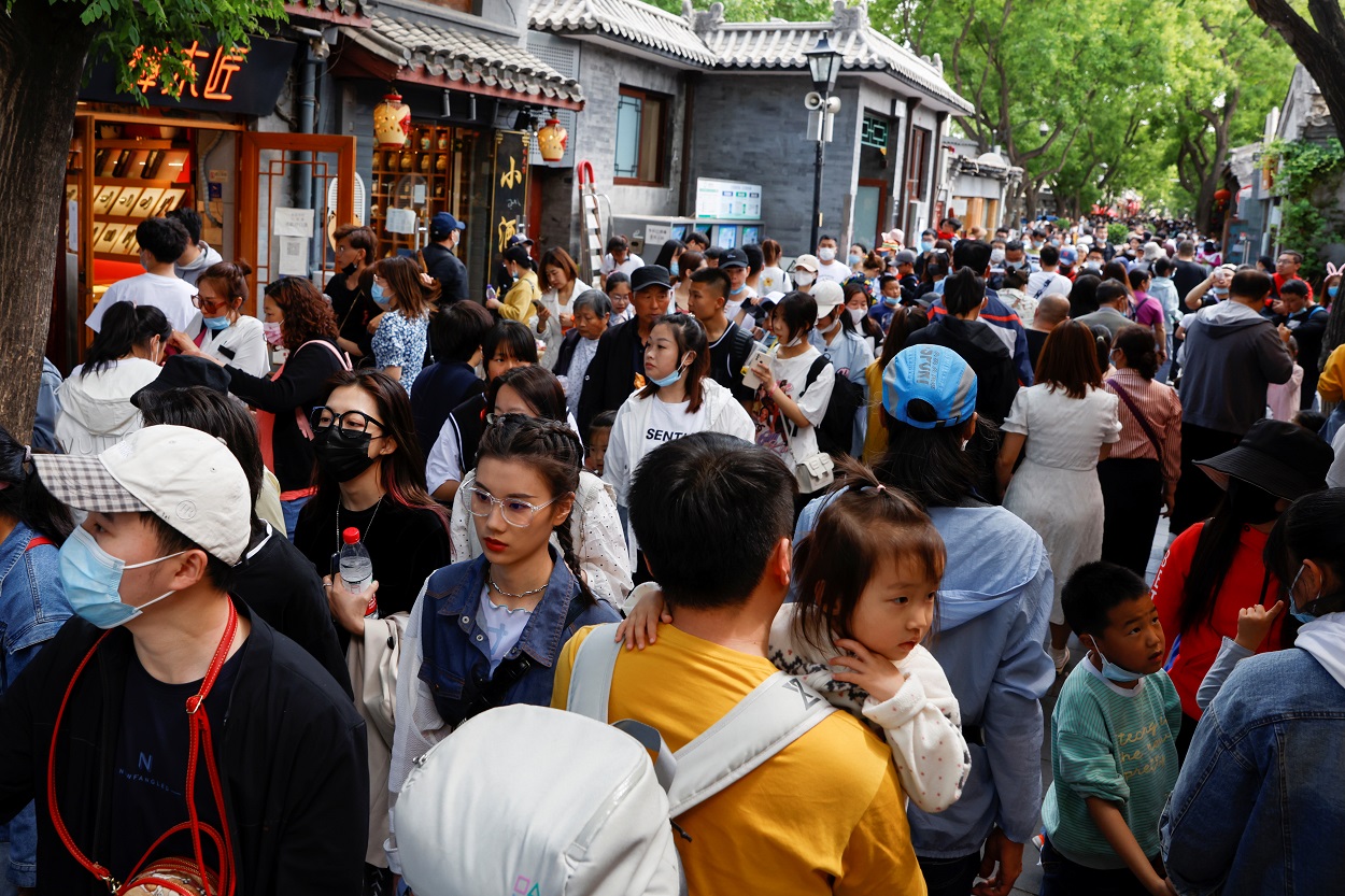 أشخاص يسيرون خلال عطلة عيد العمال، بعد تفشي فيروس كورونا، بكين، الصين، 4 مايو 2021. (رويترز)