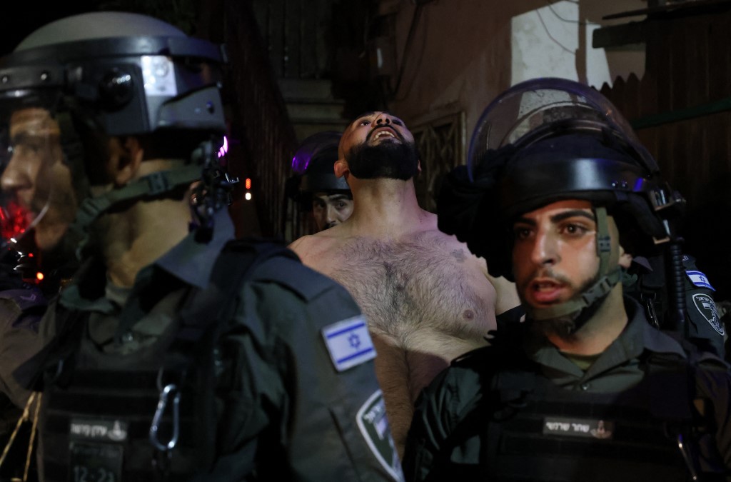 قوات الاحتلال الإسرائيلي تعتقل متظاهرا فلسطينيا في حي الشيخ جراح في القدس المحتلة، 5 أيار/مايو 2021. (أ ف ب)