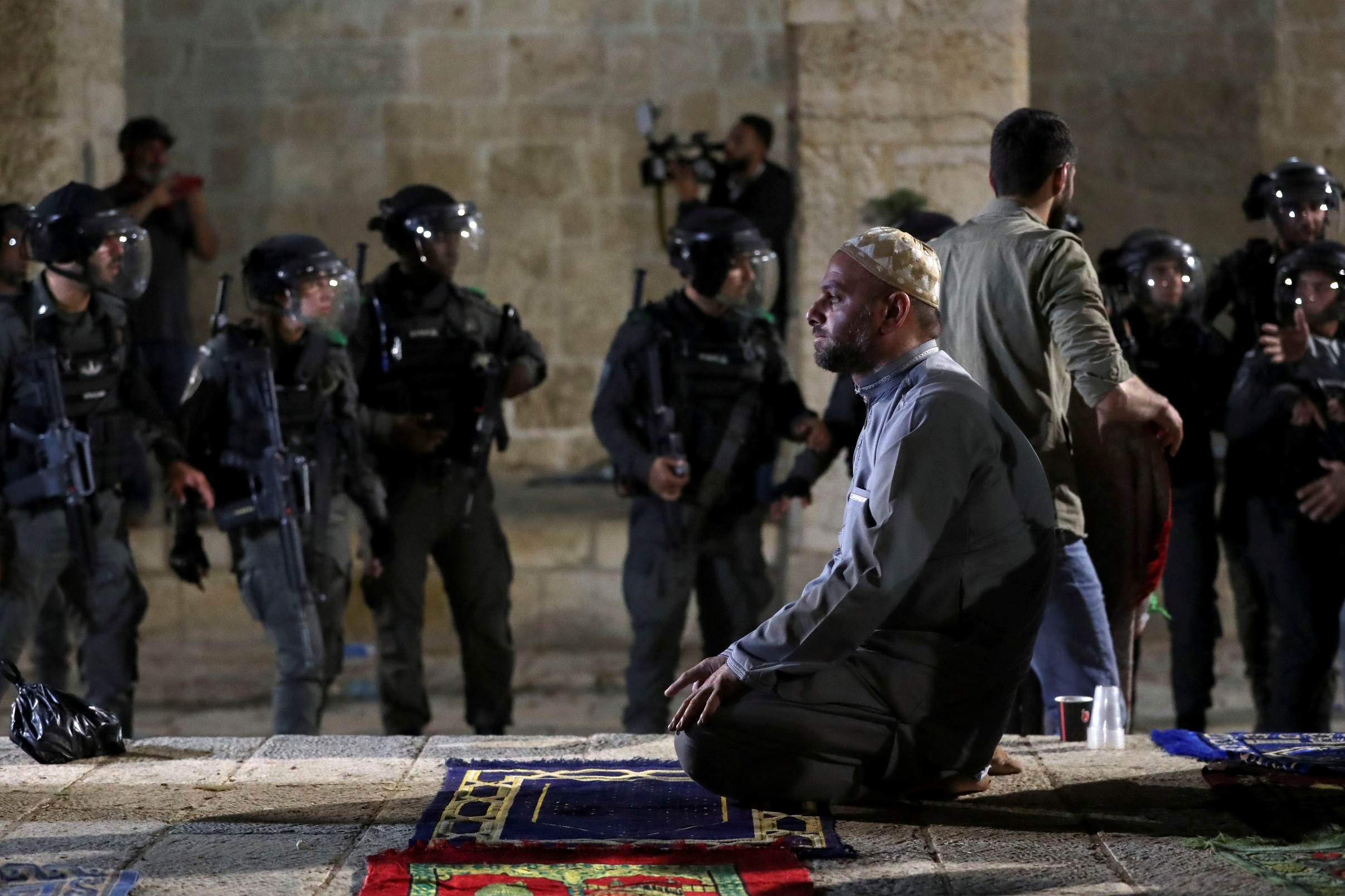 فلسطيني يؤدي الصلاة بعد اقتحام شرطة الاحتلال الإسرائيلي للمسجد الأقصى في القدس المحتلة، 7 أيار/مايو 2021. (رويترز)