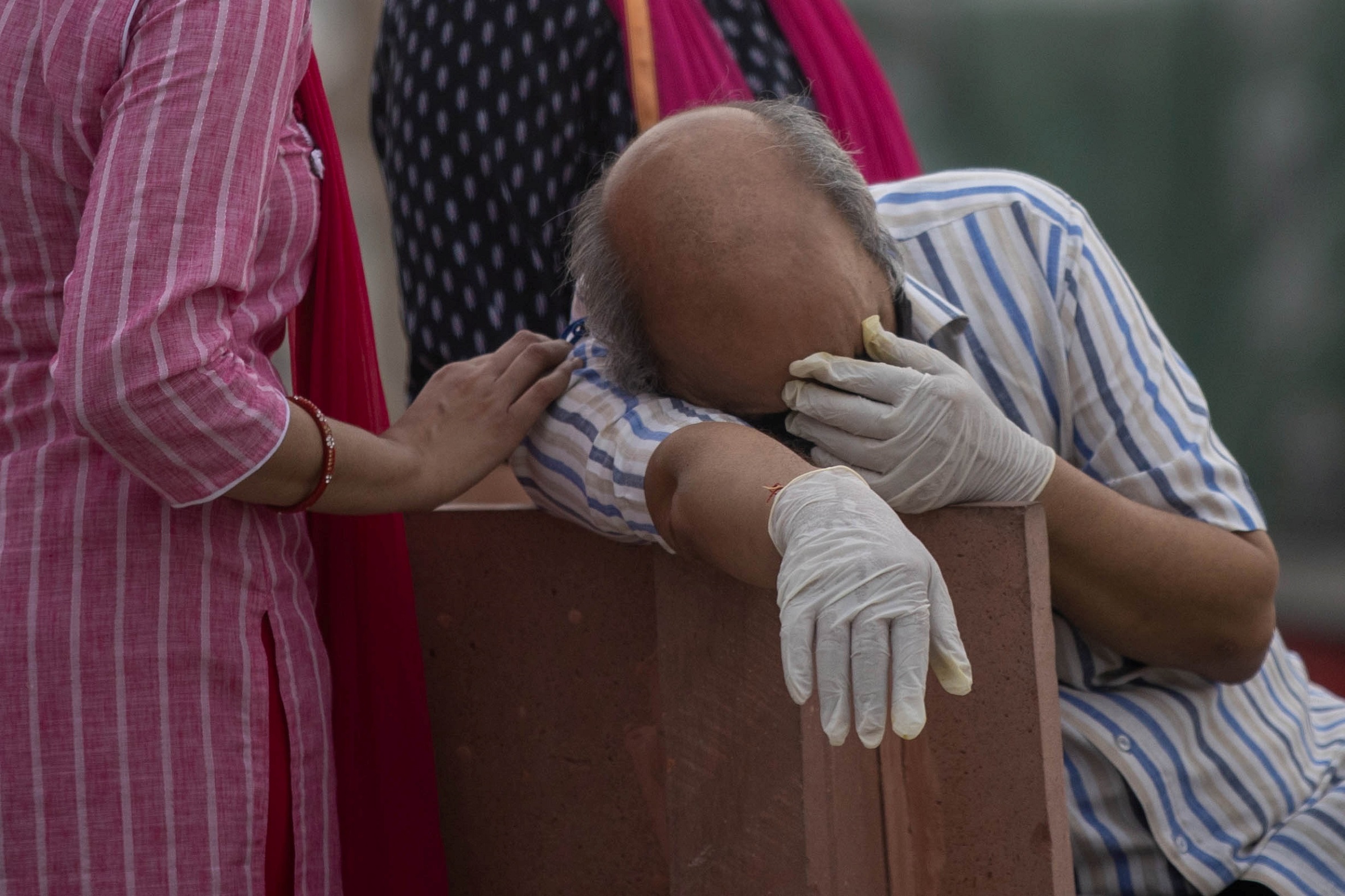 حزن يُخيم على رجل قبل حرق جثمان قريب له توفي بعد إصابته بفيروس كورونا على ضفاف نهر الغانج في ولاية أوتار براديش الشمالية في الهند. 6 أيار/مايو 2021. (رويترز)
