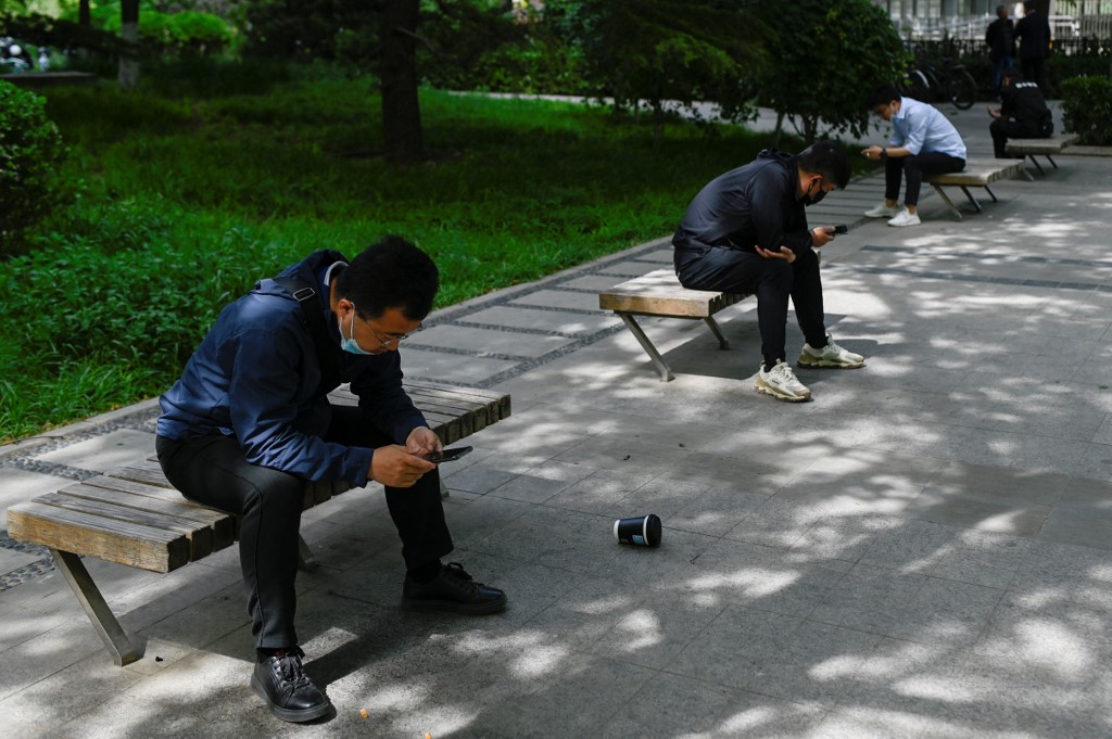 أشخاص يستخدمون هواتفهم في بكين .8 مايو 2021. (وانغ تشاو / أ ف ب)
