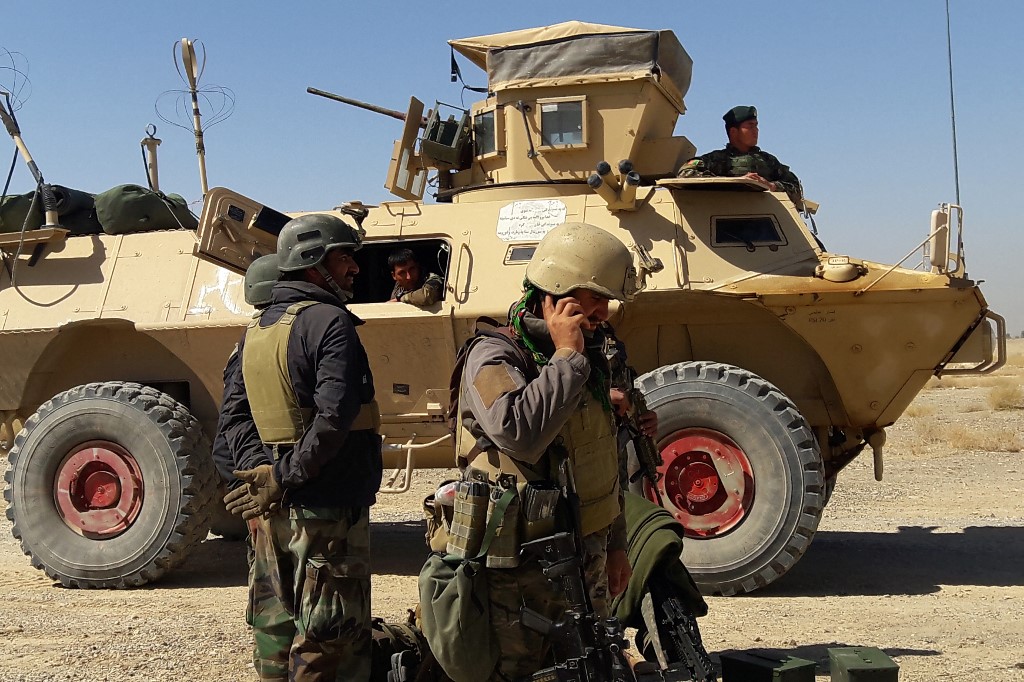 قوات أمن أفغانية بالقرب من عربة مدرعة في قتال دائر مع مقاتلي حركة طالبان. (أ ف ب)