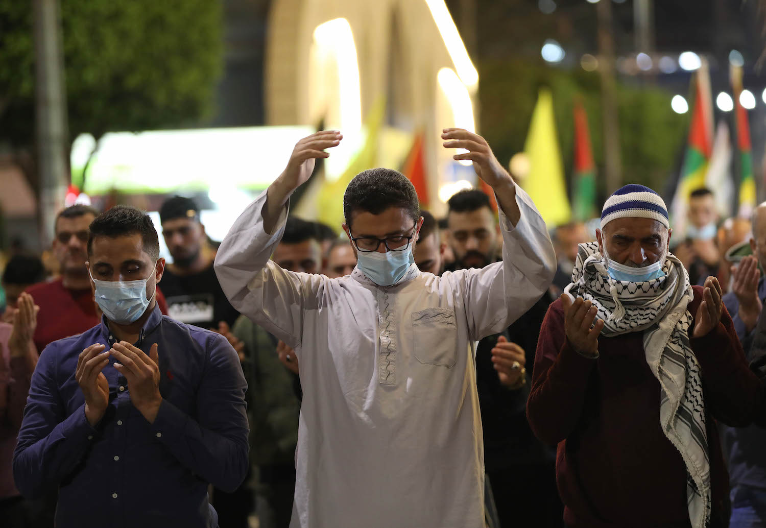 فلسطينيون يرتدون كمامات الوجه ويؤدون صلاة التروايح وسط مدينة نابلس تضامنا ودعما للقدس ضد الاعتداءات الإسرائيلية. 25/04/2021. (أيمن نوباني/وفا)