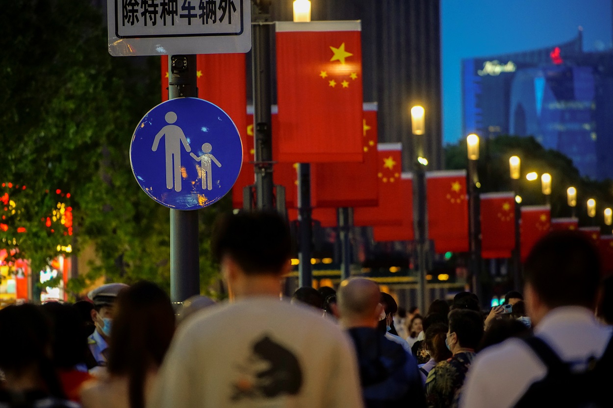 أشخاص يسيرون على طول طريق للمشاة، بعد تفشي فيروس كورونا، شنغهاي، الصين، 10 مايو 2021. (رويترز)
