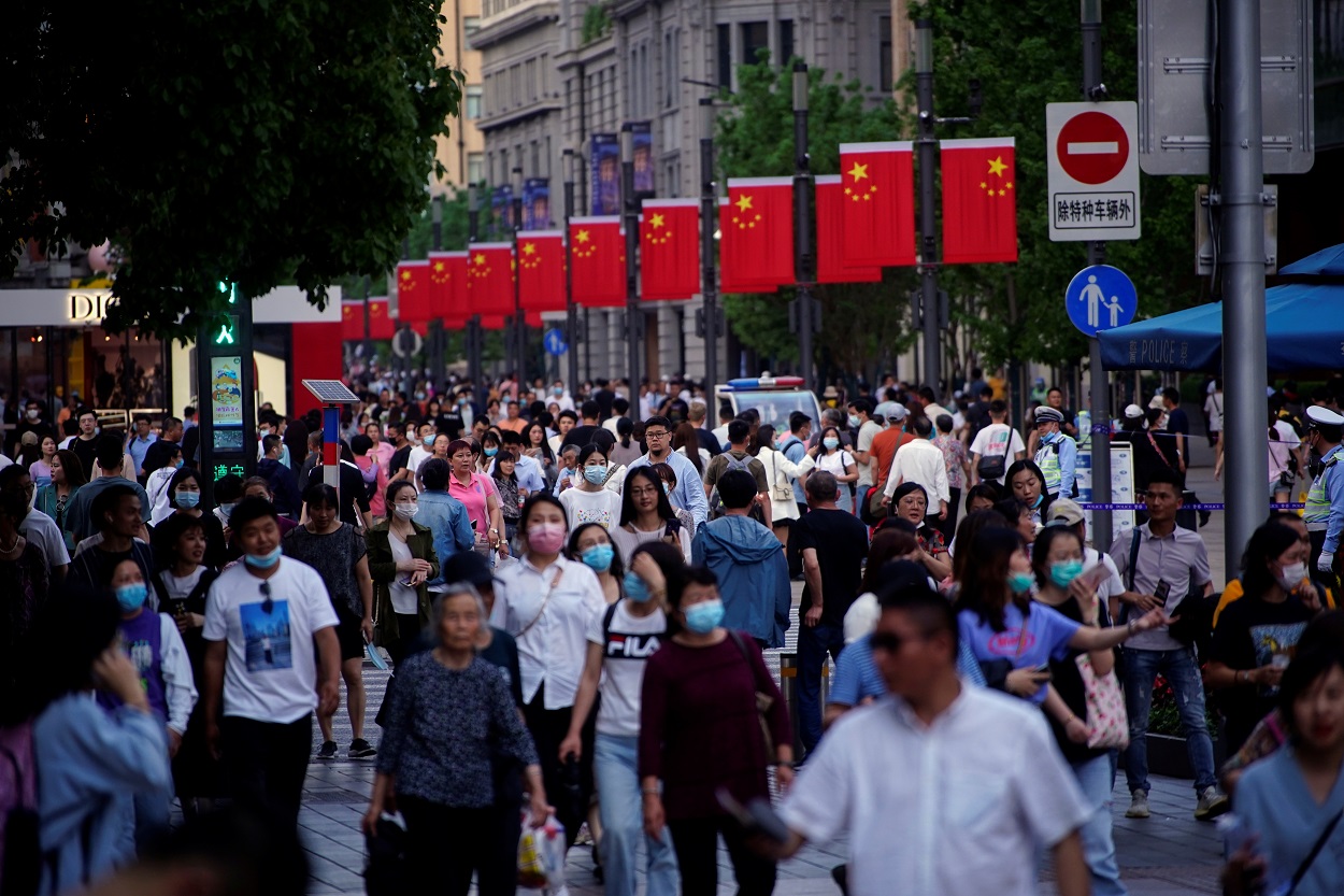 أشخاص يسيرون على طول طريق في شنغهاي، الصين، 10 مايو 2021. (رويترز)