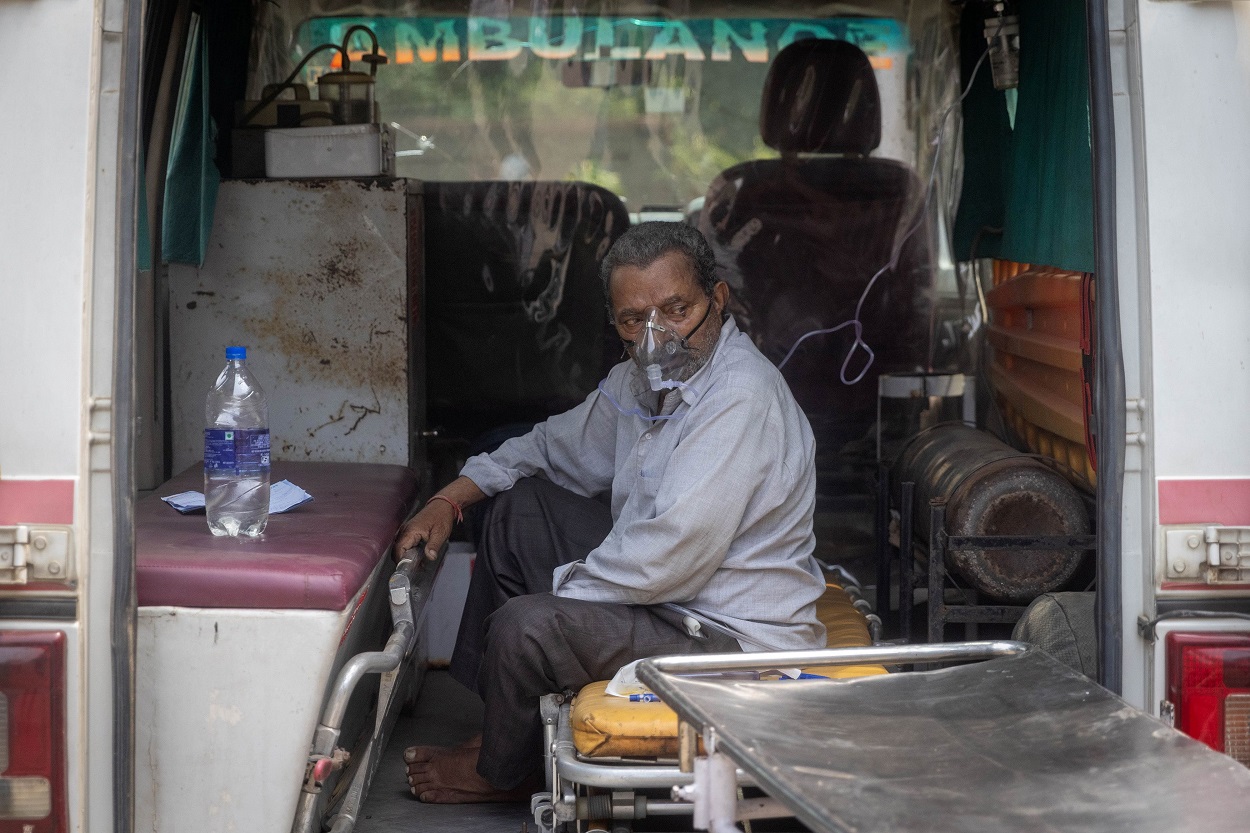 رجل يعاني من مشاكل في التنفس، يجلس داخل سيارة إسعاف في انتظار دخول مستشفى تديره الحكومة لتلقي العلاج، وسط جائحة كورونا، الهند، 11 مايو 2021. (رويترز)